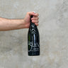 A hand holding a bottle of Berthier 2022 Terre De Silex wine against a concrete background.