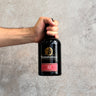 Hand holding a Bunnahabhain whisky bottle Aged 12 Years against a gray background