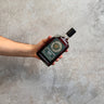 Hand holding a bottle of Cadenheads Original Collection Ardmore 11 Years against a gray concrete background