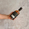 Hand holding a bottle of Cut Hill Australian Single Malt Whisky Double Cask - Foundation stone on a concrete surface