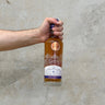 A hand holding a bottle of Gordon & Macphail Discovery Glenrothes 11 Year Old Sherry Cask Whisky.