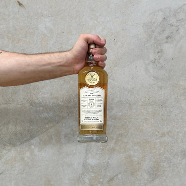 A bottle of Gordon & Macphail Connoisseurs Choice Glenlivet 2004 Whisky held in front of a grey background.