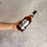 Hand holding a bottle of Hazelburn whisky oloroso cask matured against a gray concrete background