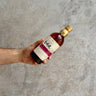 Hand holding a bottle of Japanese Nikka whisky against a concrete background. Sherry and Sweet