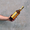 Hand holding a bottle Kavalan Ex-Bourbon Oak Taiwanese whisky against a concrete background