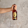 Hand holding a bottle of Michter's Limited Release Toasted Barrel Finish against a textured gray background