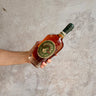 Hand holding a bottle of Michter's Straight Rye whiskey against a gray concrete background