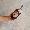 Hand holding a bottle of Michter's bourbon 20 Years Old against a gray concrete background