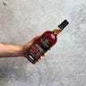 Hand holding a bottle of Morris whiskey Double Port Barrel against a concrete background