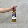 A hand holding a bottle of Oban Special & Rare Release 2022 10 Year Old Whisky against a grey background.