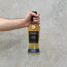 A hand holding a bottle of Pokeno Origin  Single Malt Whisky with a concrete background.