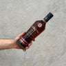 A hand holding a bottle of Pokeno Single Cask PX Whisky with a label that includes the brand name and the type of whisky.
