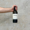 A hand holding a bottle of Port Askaig 8 Year Old Whisky with a label visible