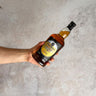 Hand holding a bottle of Springbank Whisky on a textured surface