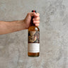Hand holding a bottle of The whisky set single malt scotch against a concrete wall