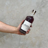 A hand holding a bottle of Waubs Harbour Limited Release PX Sherry Cask Whisky with a label visible on the front.